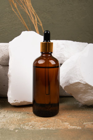 Amber glass dropper bottle with a pipette on a stone backgroundの写真素材
