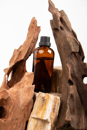 Essential oil in a brown glass bottle on a wooden background.の写真素材