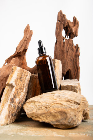 Essential oil in a glass bottle with a pipette on a background of wood and stonesの写真素材