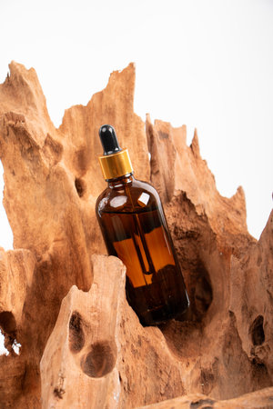 Essential oil in a glass bottle on a wooden background with barkの写真素材