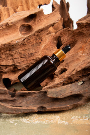 brown glass dropper bottle with pipette on wooden bark background.の写真素材