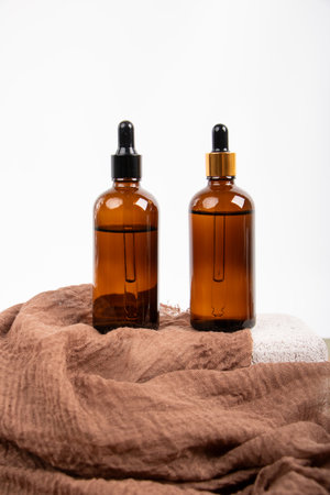Essential oil in a glass bottle on a towel on a white backgroundの写真素材