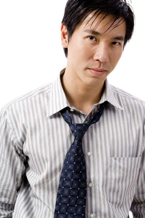 A young asian businessman with tie slightly undoneの写真素材
