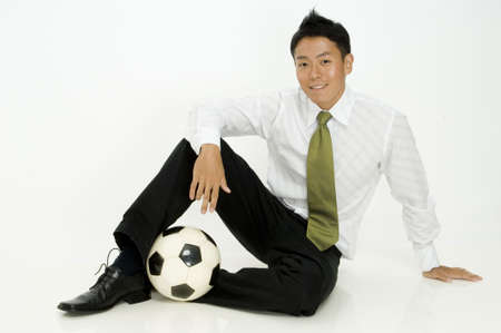 A young trendy businessman sitting with his ballの写真素材