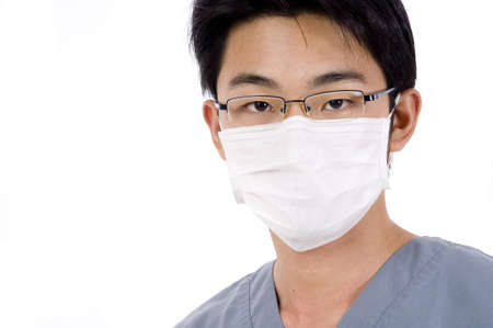 A young asian man in medical scrubs and face maskの写真素材