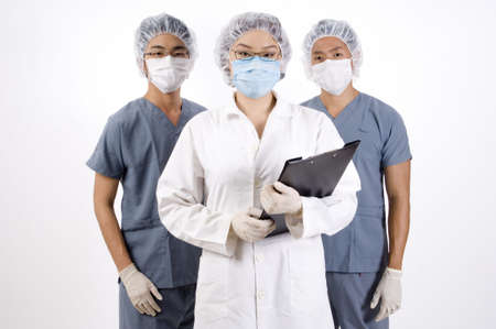 A doctor with a clipboard and two medical orderliesの写真素材