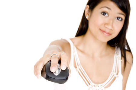 A young asian woman using a computer mouse and smiling (focus on mouse)の写真素材