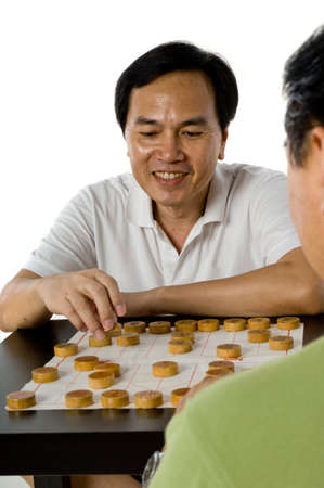 Two Chinese men in their fifties playing chess in the studio