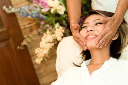 A young Asian woman having a face massage in a beauty salonの写真素材