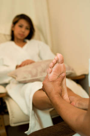 A young Asian woman having her foot massagedの写真素材