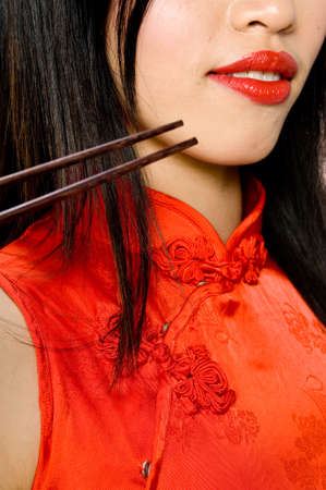 A model in traditional dress holding chopsticksの写真素材