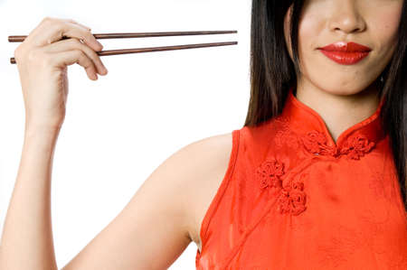 A model in traditional dress holding chopsticksの写真素材