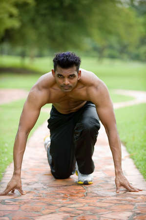 A young man getting ready to run outside in track pants