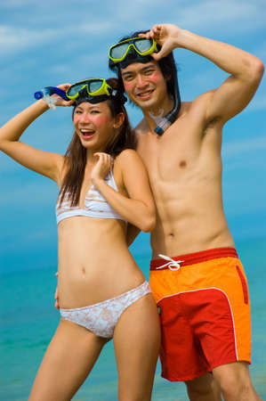 A young couple with snorkelling gear on a tropical beachの写真素材