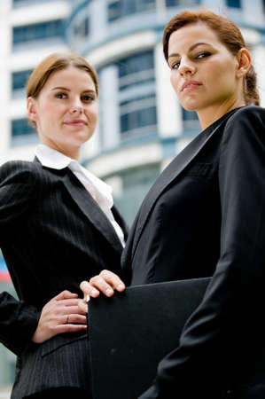 Two young businesswoman in the city with buildings behindの写真素材