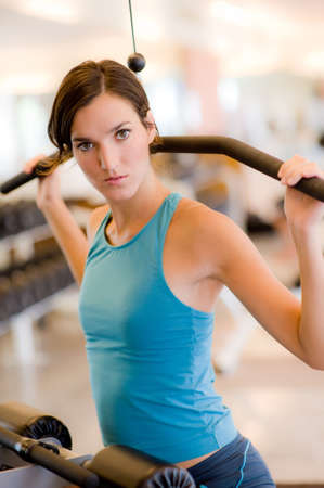 A young woman working out on a machine in a gym
