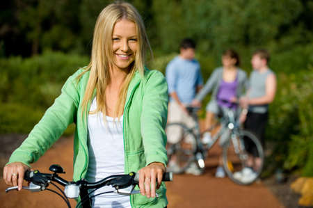 A young woman on a bike with group of friends in background