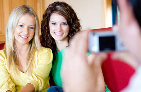 Two attractive young woman have their photo taken by a friendの写真素材