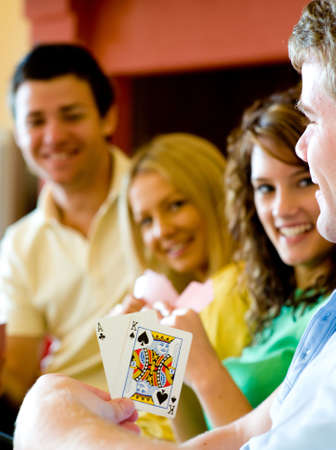 Four friends playing poker at homeのeditorial素材