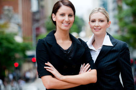 Two young professional businesswomen standing in the city (only one in focus)の写真素材