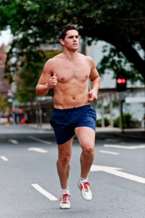 A good-looking man is out running in the cityの写真素材
