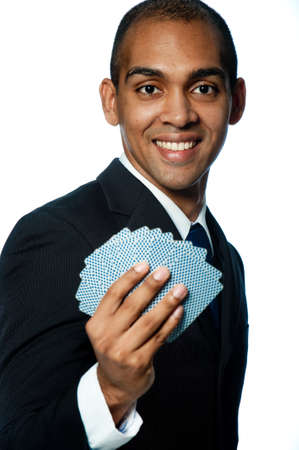 A young black businessman holding out a deck of cards on white backgroundの写真素材