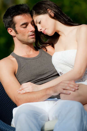 A good-looking couple sitting together outside in the sun on vacationの写真素材