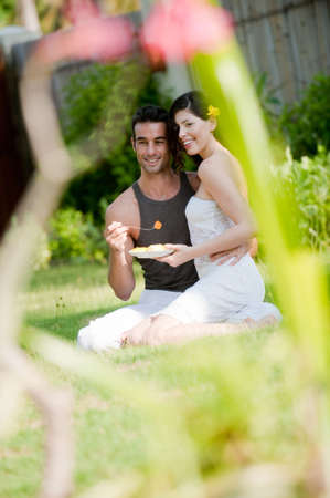 A young attractive couple eating a healthy breakfast outsideの写真素材