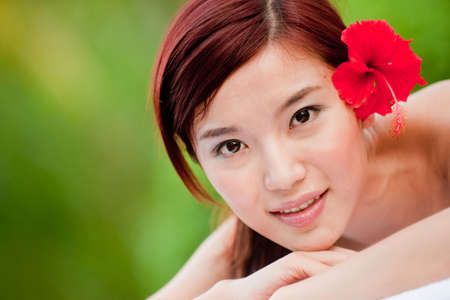 A young Chinese woman lying on a massage table outsideの写真素材