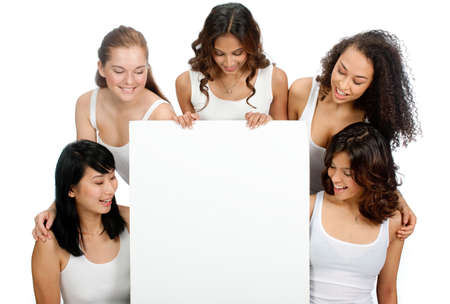 A group of teenagers with diverse ethnicities looking at a blank sign against white backgroundの写真素材
