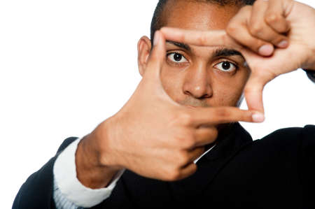 A young businessman looking through a shape made with his fingersの写真素材