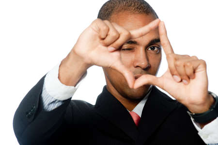 A young businessman looking through a shape made with his fingersの写真素材