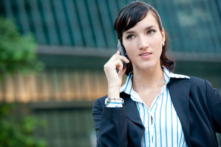 An attractive young businesswoman using her phone in the cityの写真素材
