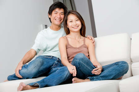 A good looking couple relaxing on their couch at homeの写真素材