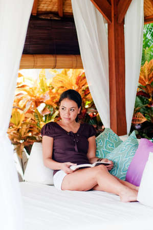 An attractive woman reading book on the couchの写真素材