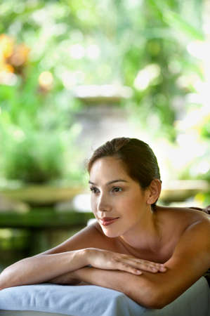 An attractive caucasian woman lying down on a massage bed at a spaの写真素材