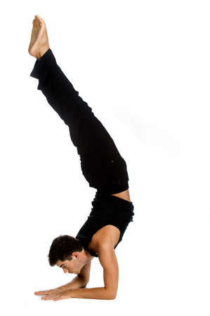 An athletic man doing a handstand against white background