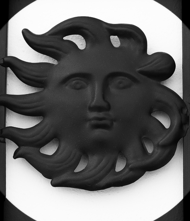 Black iron sun ornament, white backgroundの写真素材