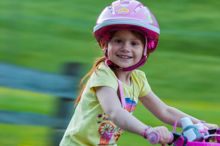 Little girl bicycling, background blurred, panningの写真素材