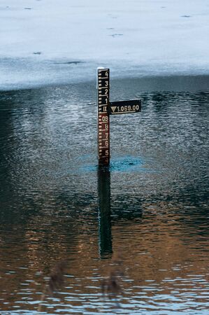 water depth measurement tool in mountains partially iced lake in Tyrol (Austria)の写真素材