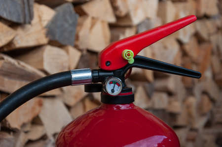 fire extinguisher: detail of the pressure gauge, pile of wood in backgorundの写真素材