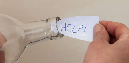 a woman's hands put-take a help message in a bottle