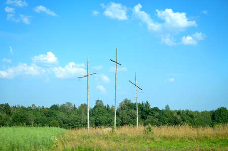 Three crosses in a green valley under blue skyの写真素材