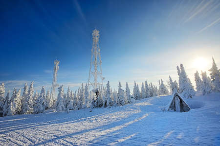Ski Station and cell tower on the mountain. Low temperatures and lots of snow. All the trees are...