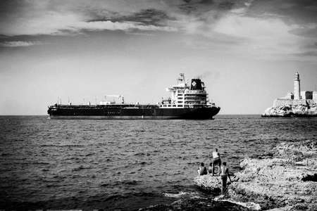 HAVANA, CUBA - MAY 17, 2016: Seafront Malecon in Havana. Ship in the Atlantic Ocean. View to the lighthouse and the entrance to Havana bay.のeditorial素材