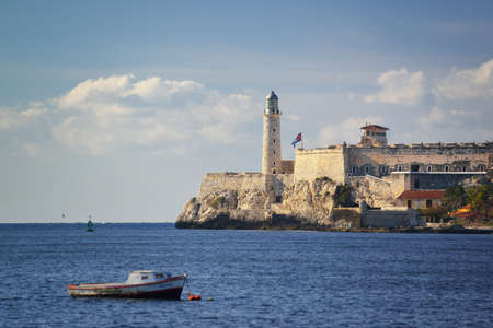 HAVANA, CUBA - May 16, 2016: Boats in the Atlantic Ocean on a sunny day. View to lighthouse and El Morro Castle from the seafront. Fortress guarding the entrance to Havana bay.のeditorial素材