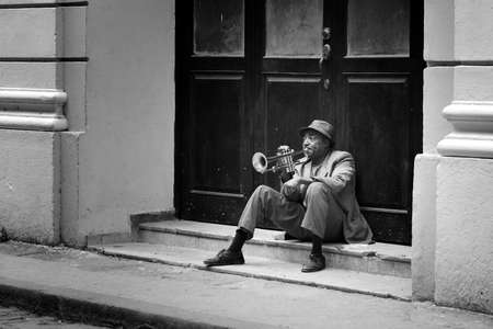 HAVANA, CUBA - MAY 19, 2016: Musician is playing saxophone in the street of Old Havana. Black and white colour of Cuba.のeditorial素材