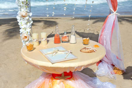 Accessory kit for a wedding is on the shores of the Caribbean Sea. Arch is decorated with curtains and flowers.の写真素材