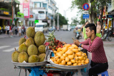 NHA TRANG, VIETNAM - JUNE 19, 2016: Merchant is selling fruits and vegetables in the touristic street in the downtownのeditorial素材