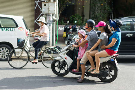 NHA TRANG, VIETNAM - JUNE 20, 2016: Mother, father and two daughters are riding the motorcycle on the street in the downtown of Vietnamのeditorial素材
